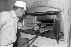 Mr Turney removing the baked bread from the oven.